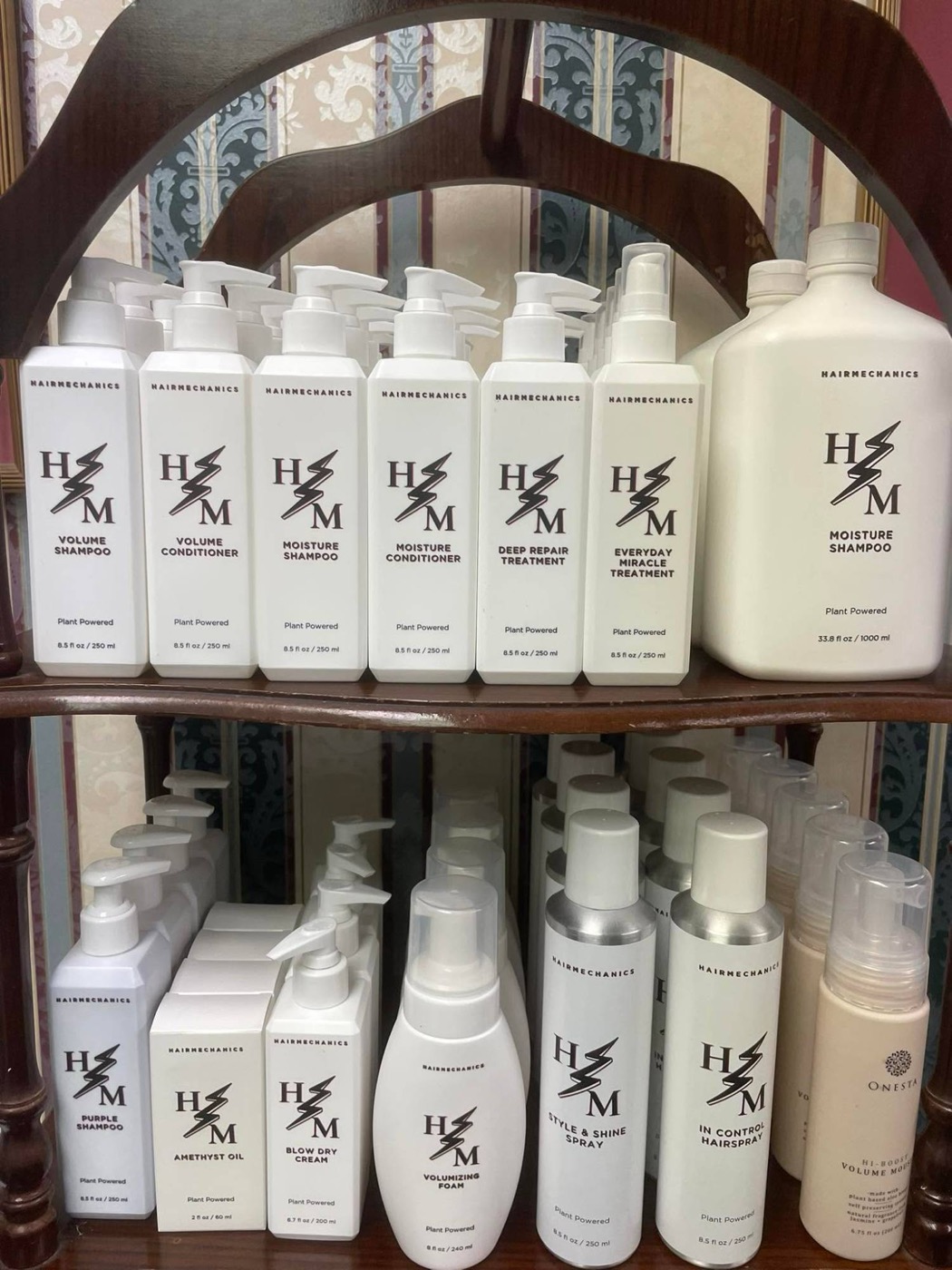 Shelves of white Hair Mechanics bottles: shampoos, conditioners, treatments and styling products